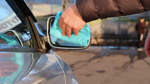A man using microfiber wipes a side mirrors in a car. Car care concept. Stock-Footage 124125833