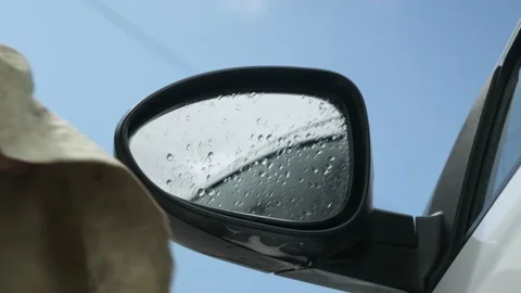 A man using microfiber wipes a side mirrors in a car Stock Footage 131171098