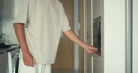 Man using microwave for lunch, microwave boosting convenience in modern kitchen Stock Footage 312122426