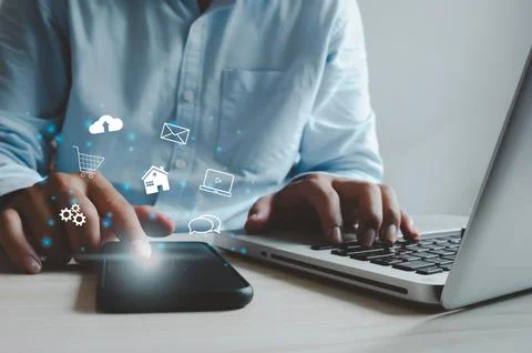 Man using the mobile app and computer laptop online shopping..Co Stock Photos