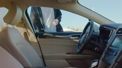 Man using mobile app to unlock rental car in urban environment, showcasing Stock Footage 315529401