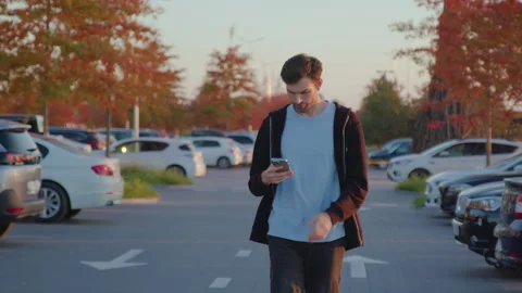 Man using mobile application to unlock rental car in urban parking lot Stock Footage 317702099