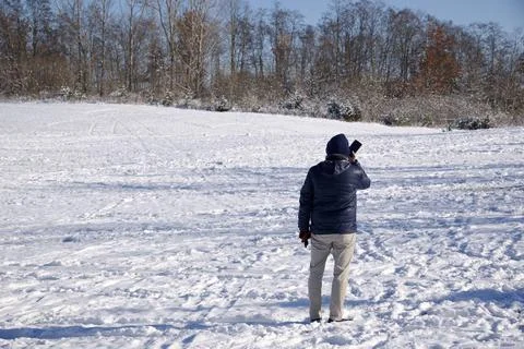 Man using the mobile cell phone in the public park in winter Stock Photos