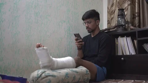 A man using mobile in the night in a dark room with a table lamp on. Stock Footage 147237435