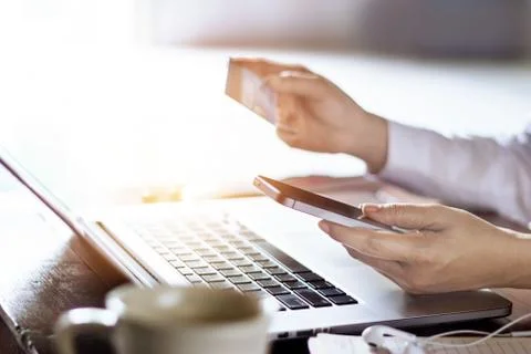 Man using mobile payments with credit card for online shopping on laptop Фото