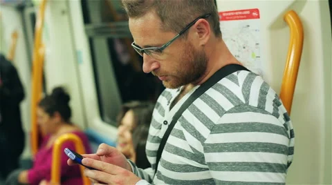 Man using mobile phone and standing in subway, steadycam shot Stockbeeldmateriaal 42979206