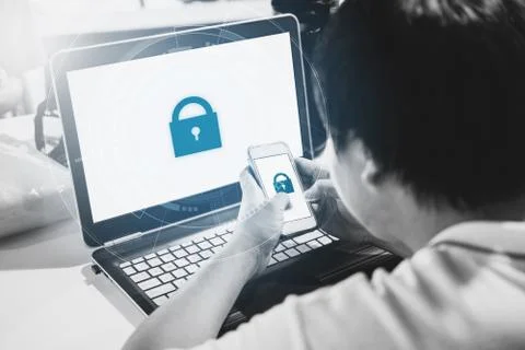 A man using mobile phone and computer laptop with lock icon technology on screen Stock Photos