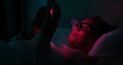 Man using mobile phone in bed at night Stock Footage 145292312
