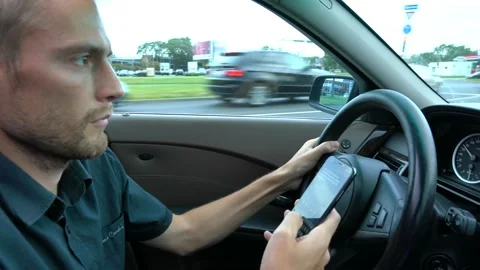 Man using mobile phone at the car. Unsafe drive and texting Stock Footage 144687910