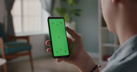 Man using a mobile phone with chroma key green screen, watching a video or Stock Footage 139355566