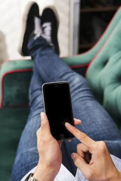 Man using a mobile phone on a couch Stock Photos