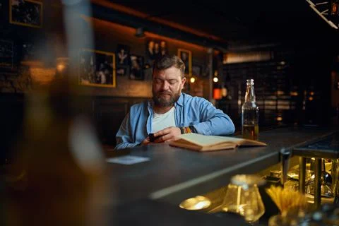 Man using mobile phone at the counter in bar Stock Photos