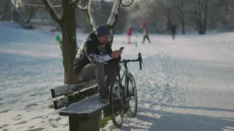 Man using a mobile phone for GPS during a winter bike commute in Munich. A Stock Footage 330902538