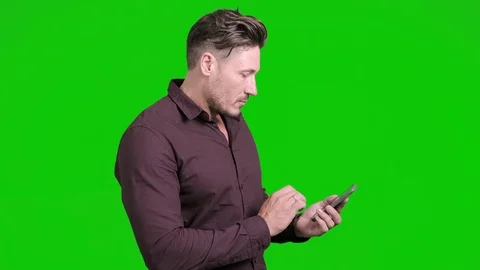 Man using mobile phone on green screen. Typing text. Stock Footage 105304739