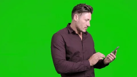 Man using mobile phone on green screen. Typing and talking. Stock Footage 105304804