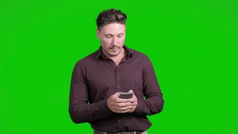 Man using mobile phone on green screen. Typing very hard. Stock Footage 105304905