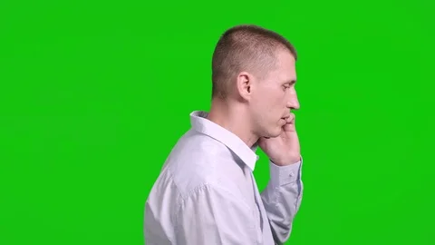 Man using mobile phone on green screen. Serious talk, side shot. Stock Footage 105305495