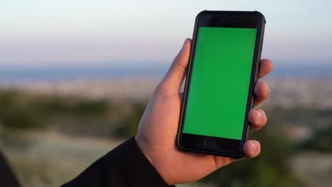 Man using mobile phone with green screen against sky view Stock Footage 133374835