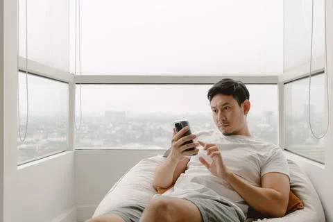 Man using mobile phone for killing time with social media online games and .. Foto stock