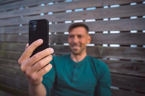Man using mobile phone. Looking at smartphone and having a facetime video call Stock Photos