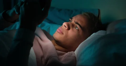 Man using mobile phone lying on bed Stock Footage 145289513