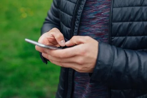 Man using mobile phone in the park. Close up. Stock Photos