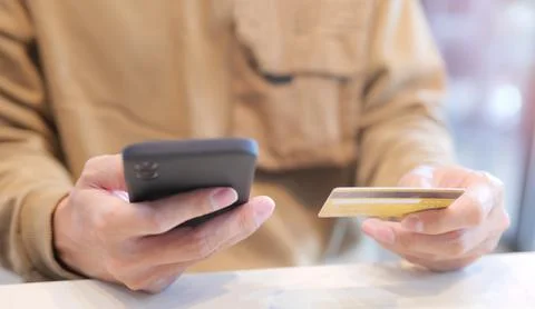 Man using mobile phone to pay with credit card via mobile banking. Stock Photos