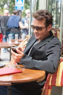 Man using a mobile phone in a restaurant, Paris, Ile-de-France, France 写真素材