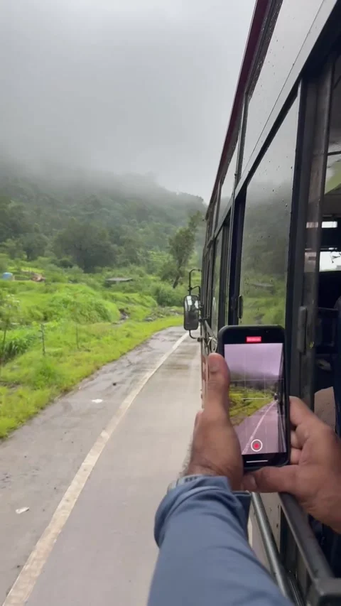 Man using a mobile phone to shoot the scenic misty roads of western ghats Stock Footage 337547777