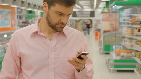 Man Using Mobile Phone In Shopping Store Stock Footage 63365534