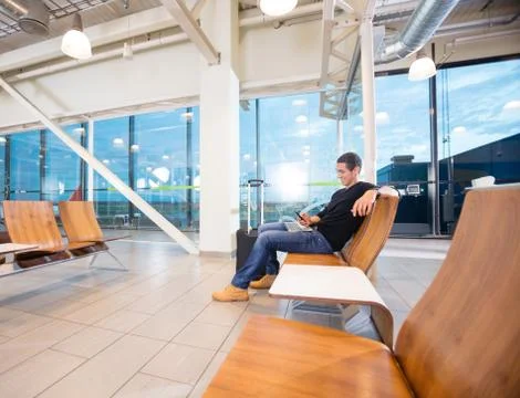 Man Using Mobile Phone While Waiting For His Flight Stock Photos