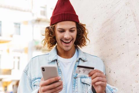 Man using mobile phone while holding credit card Stock Photos