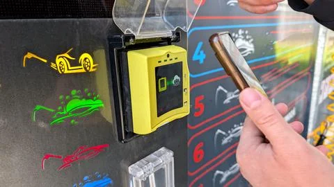Man Using Mobile Phone For Wireless Payment At Car Wash Terminal Stock-Fotos