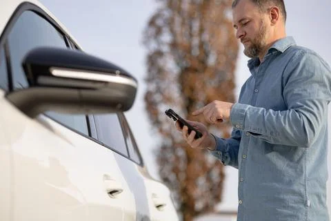 Man using mobile security system near vehicle. use of mobile vehicle securi.. Stock Photos