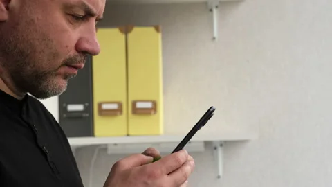 Man using mobile smart phone in office side view. Businessman holding smartphone Video stock 237873077