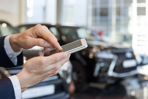 Man using mobile smart phone at dealer showroom. Foto stock