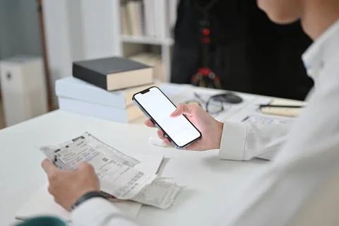 Man using mobile smart phone for paying electricity bills at desk. Internet Foto stock