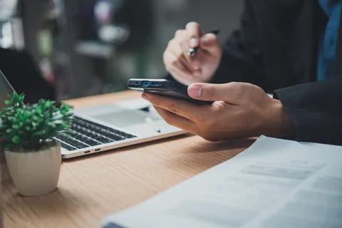 Man using mobile smart phone and working on laptop computer.education and t.. Stock Photos