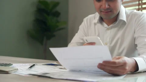 Man using a mobile smartphone to scan the QR code from an invoice on a docume Video stock 217963166