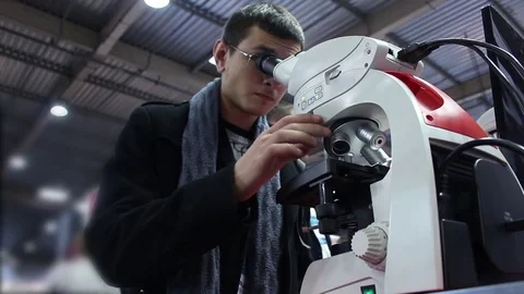 Man using a modern microscope Stock Footage 73387668