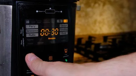 Man using modern multi cooker in kitchen. choosing program Stock-Fotos