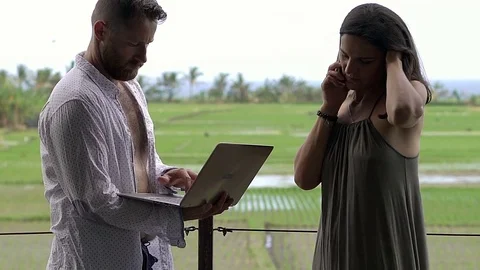 Man using modern notebook while his girlfriend is speaking on cellphone, close u Stock-Footage 83677804