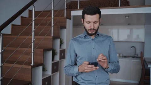 Man using modern smartphone and sending message at home Video stock 110803892