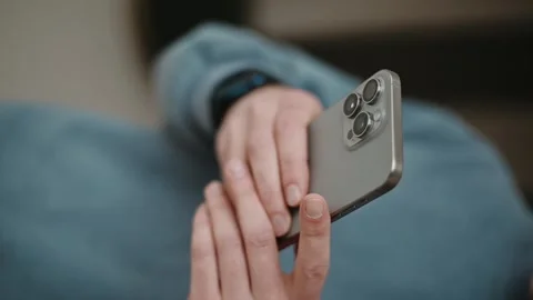 Man using a new mobile phone, iphone 15 smartphone close-up. scrolling Stock Footage 260930205