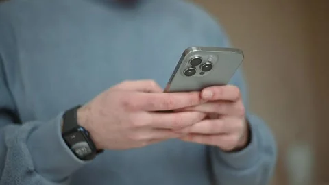 Man using a new mobile phone, iphone 15 smartphone close-up. Stock Footage 260930259