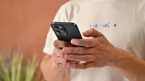 Man using a new mobile phone, iphone 15 close-up, scrolling Stock Footage 273974330