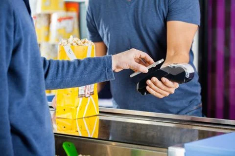 Man Using NFC Technology To Make Payment At Cinema Stock Photos