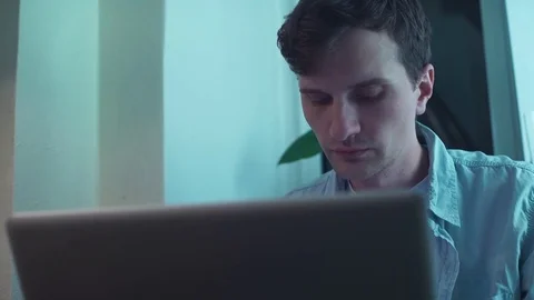 Man using notebook computer sitting near window Stock Footage 83871084