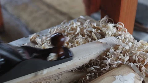 Man using old steel carpenter brush carving a wooden stick, in his workshop Stock Footage 203085784