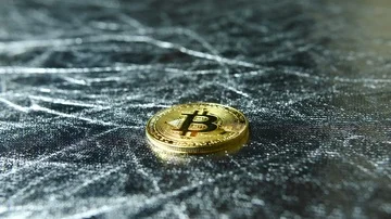 Man using one gold BTC bitcoin crypto currency to buy something on table  Stock Footage 85688392